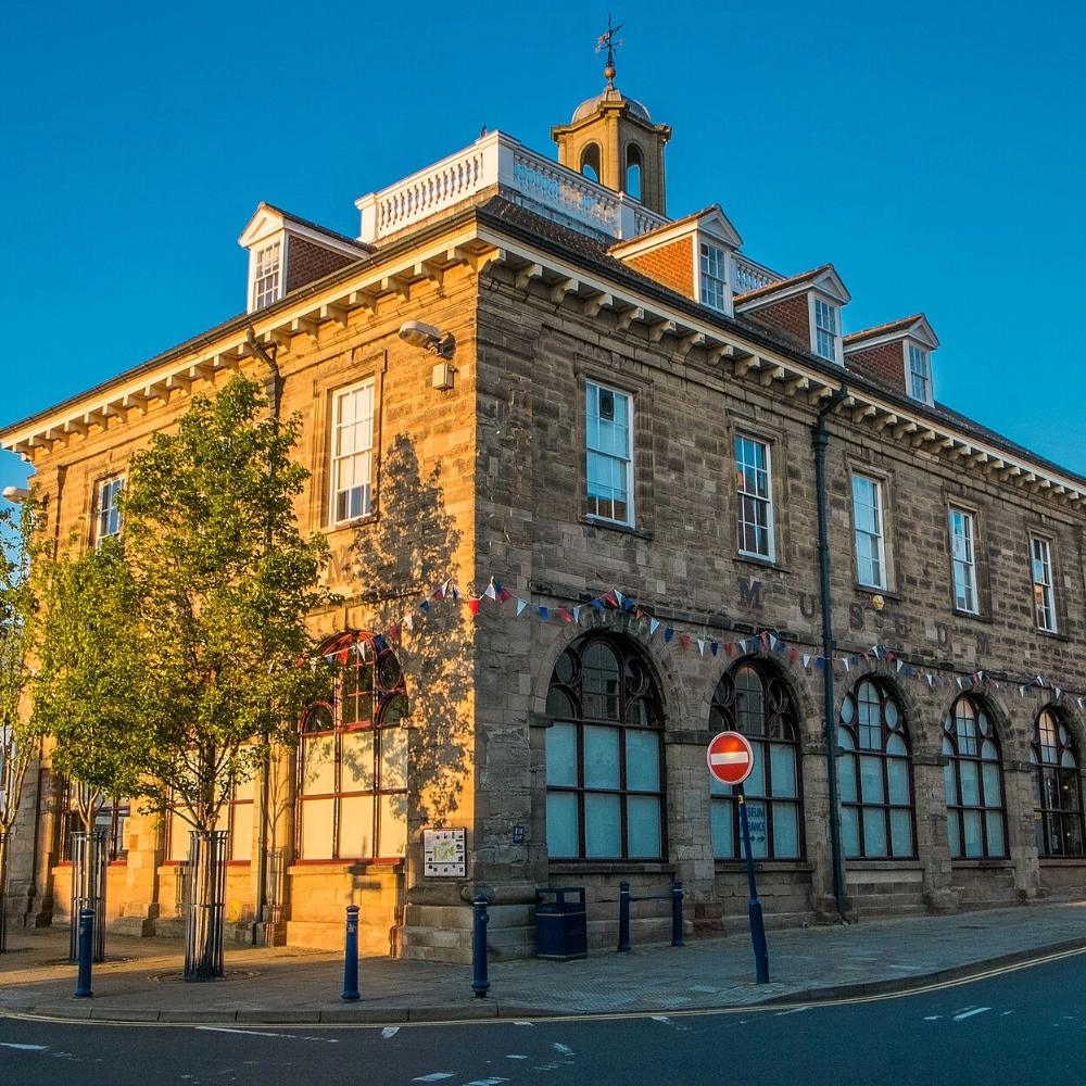 Exterior of the Market Hall Museum building in Warwick’s Market Square, a historic 17th-century sandstone structure now home to the Warwickshire Museum, showing the museum’s façade and entrance where local archaeology, natural history and county heritage exhibits are displayed in the heart of the town centre.